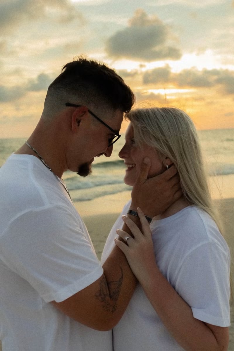 Engaged couple forehead to forehead on the beach at sunset